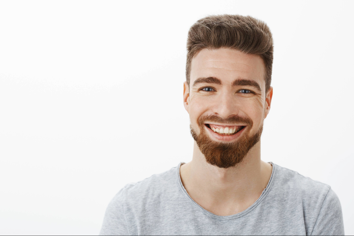 waist-up-shot-charming-carefree-optimistic-handsome-man-with-beard-moustache-cute-blue-eyes-laughing-joyfully-squinting-from-joy-amusement-having-fun-against-gray-wall (1)